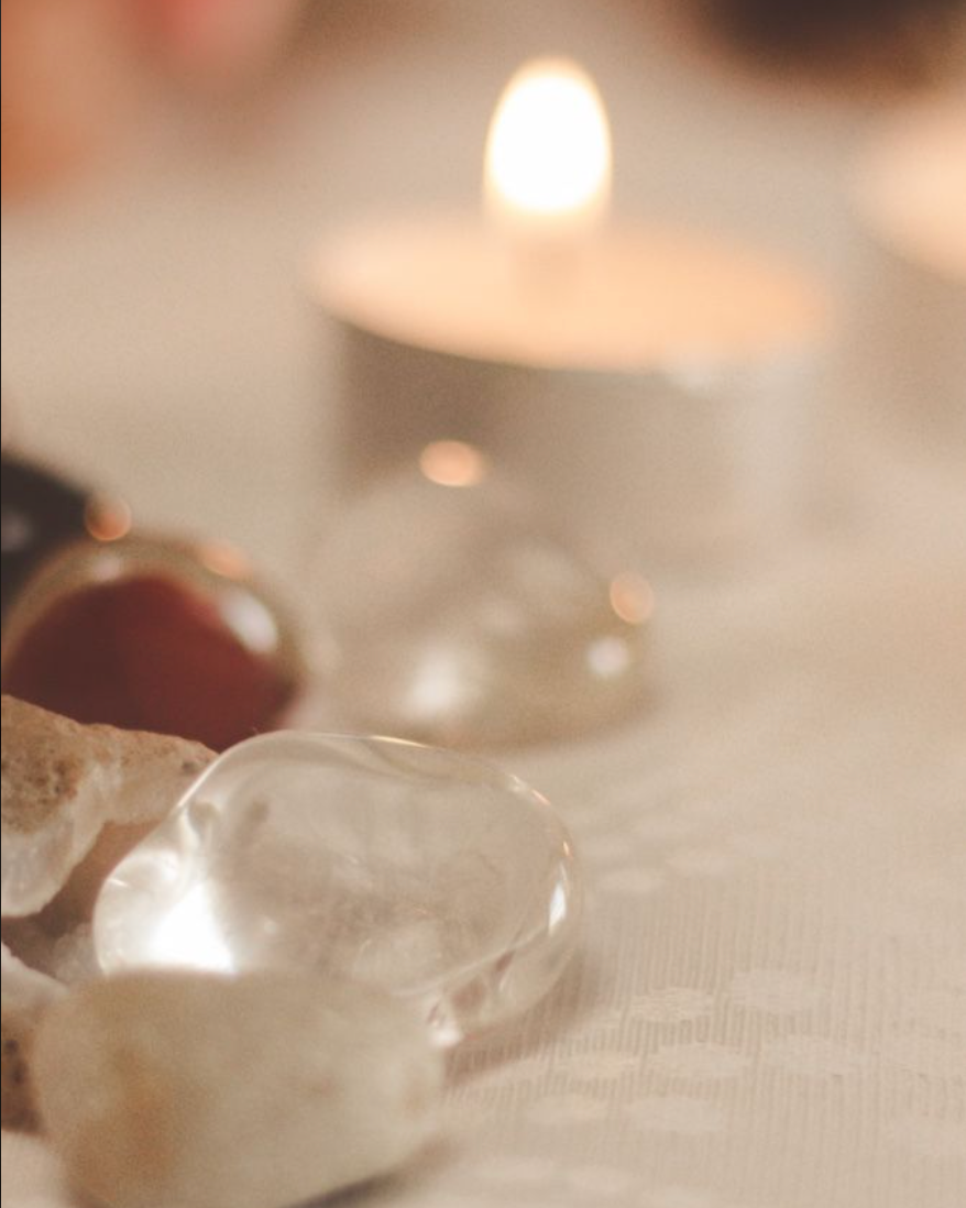 Healing corner setup with clear healing stones and a softly glowing candle for meditation and relaxation