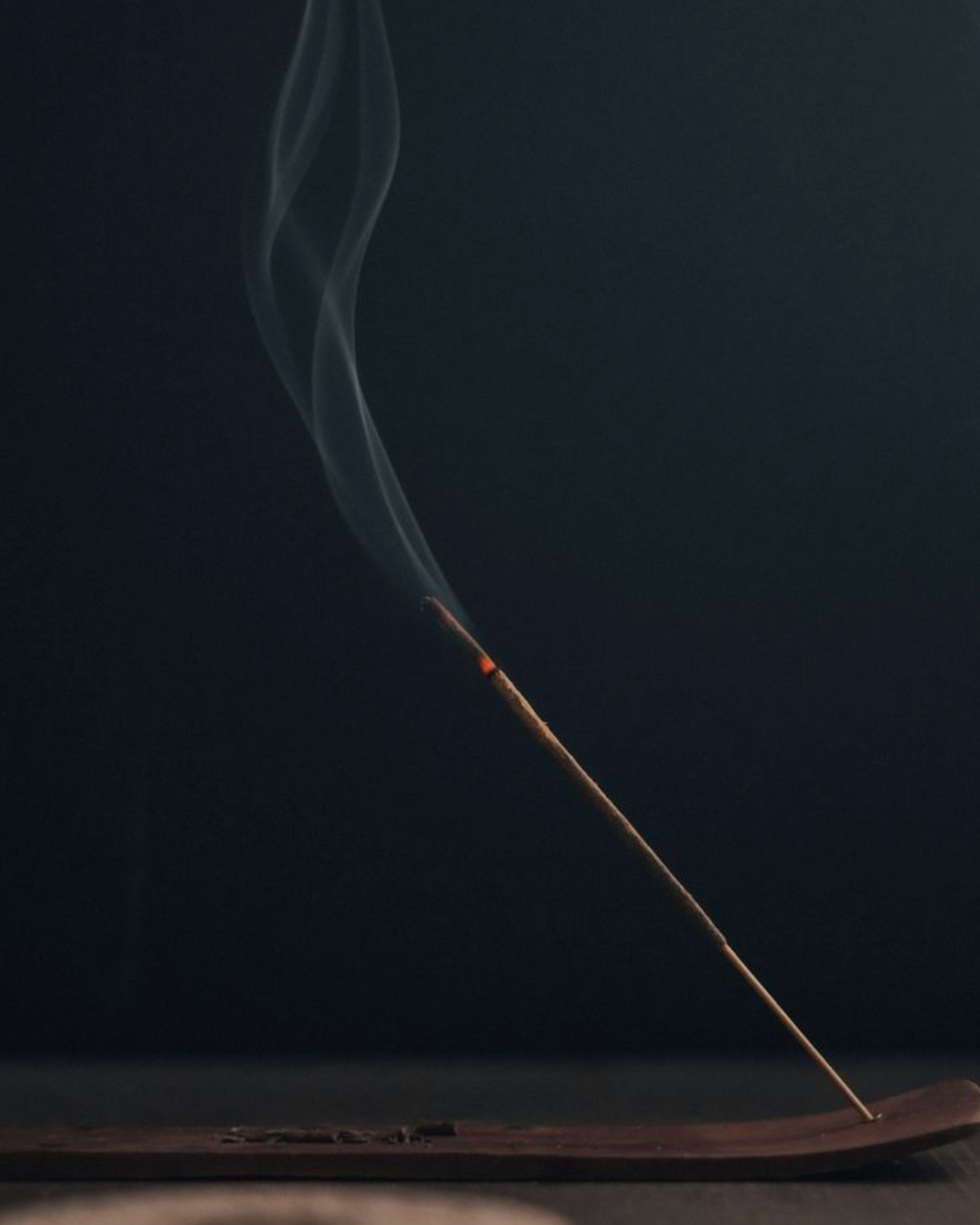 Burning natural incense stick releasing smoke as a calming sleep aid for relaxation