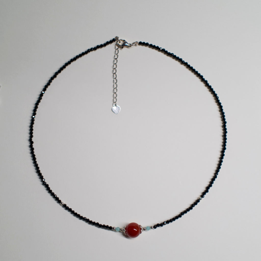 AuroraGems black beaded necklace with a central red Abundance Crystal bead by archeast