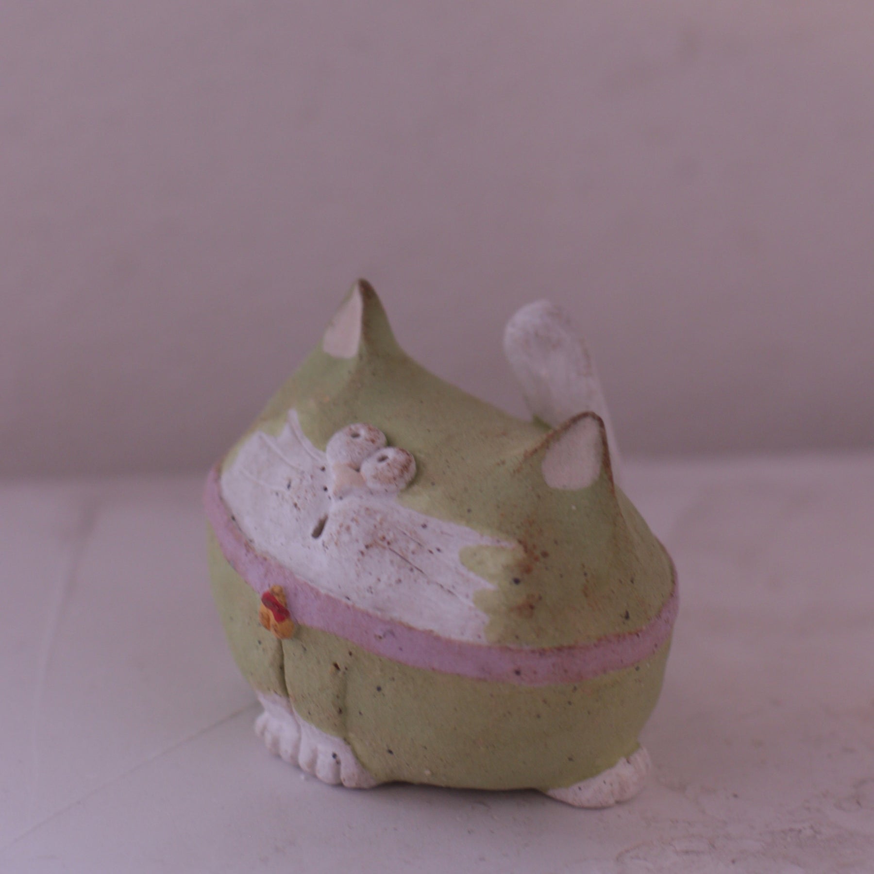 Handmade green and white clay cat figurine with pink accents and detailed facial features