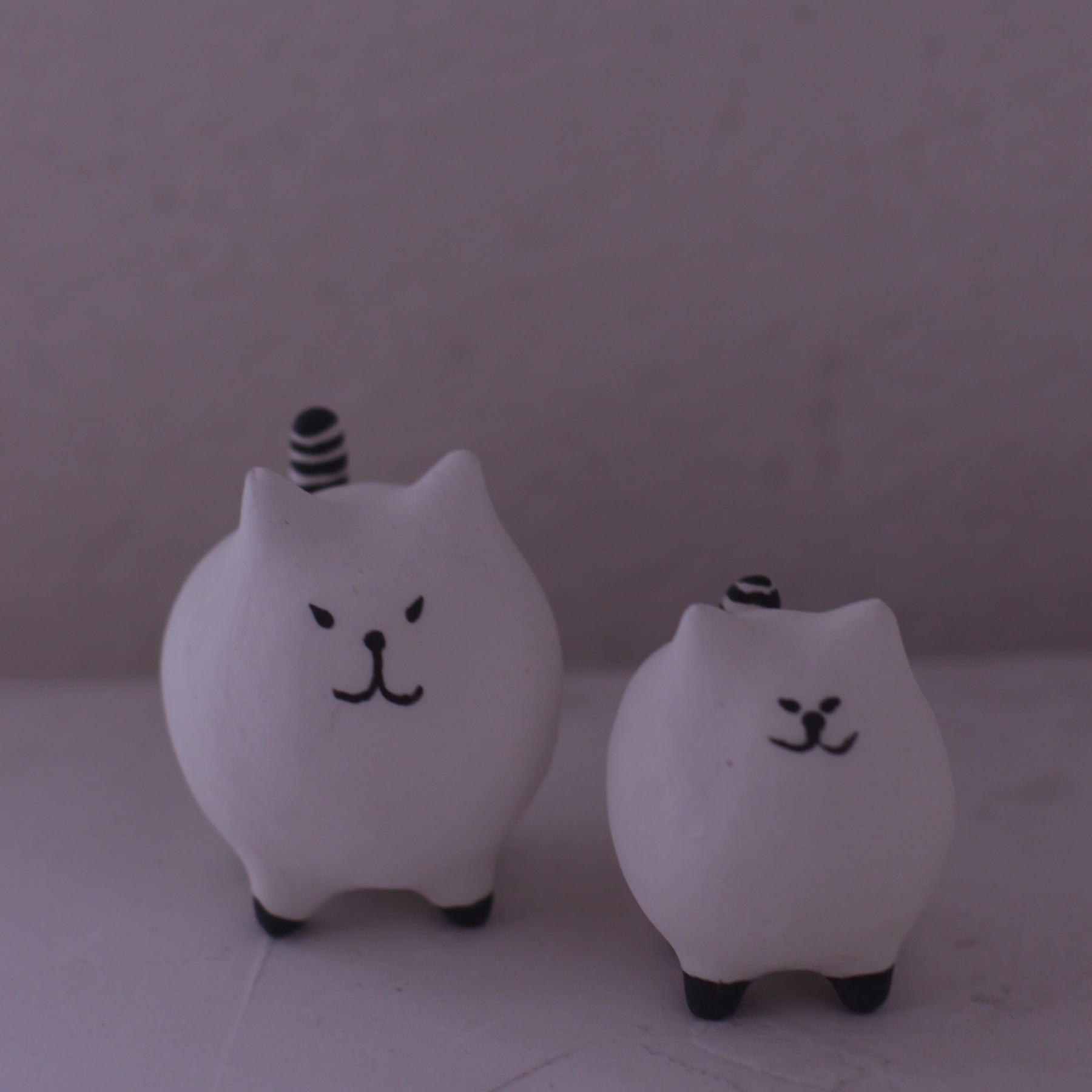 Handmade clay cat figurine set with simple black facial features and striped tails