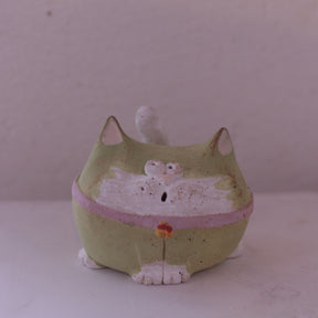 Handmade clay cat figurine pottery in green with white accents and a pink collar by various artist