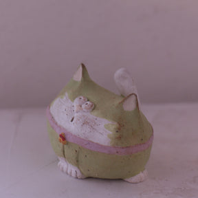 Handmade green and white clay cat figurine with pink accents and detailed facial features