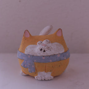 Handmade Clay Cat Figurine with orange body and blue scarf by various artists