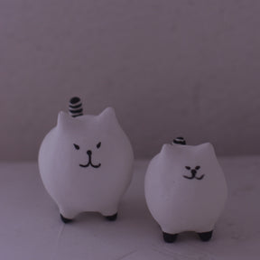 Handmade clay cat figurine set with simple black facial features and striped tails