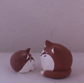 Handmade Clay Fox Figurine pottery set featuring two brown and white foxes by Various Artist