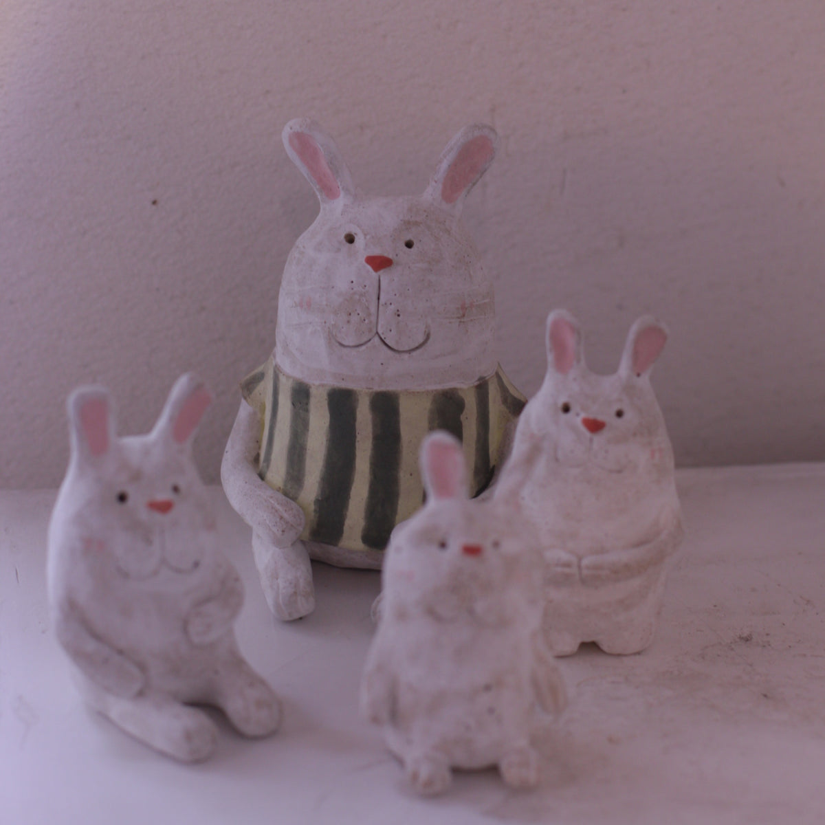 Handmade Clay Rabbit Figurine group with detailed facial features and striped green shirt by Various Artist