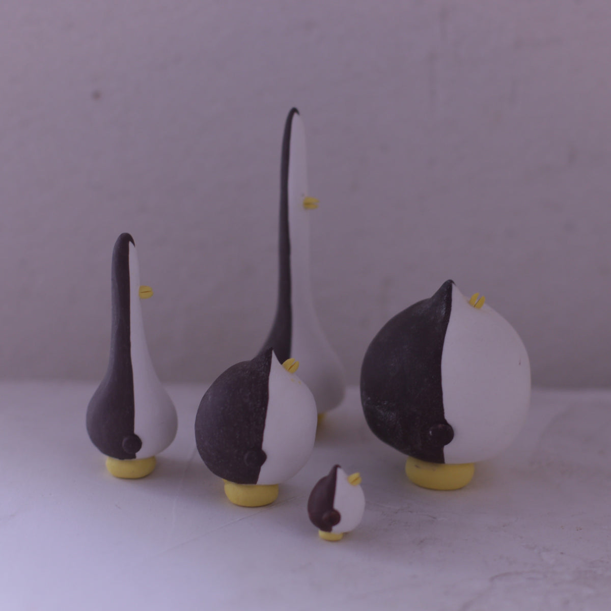 Handmade pottery animal figurine set in black and white with yellow accents by various artists