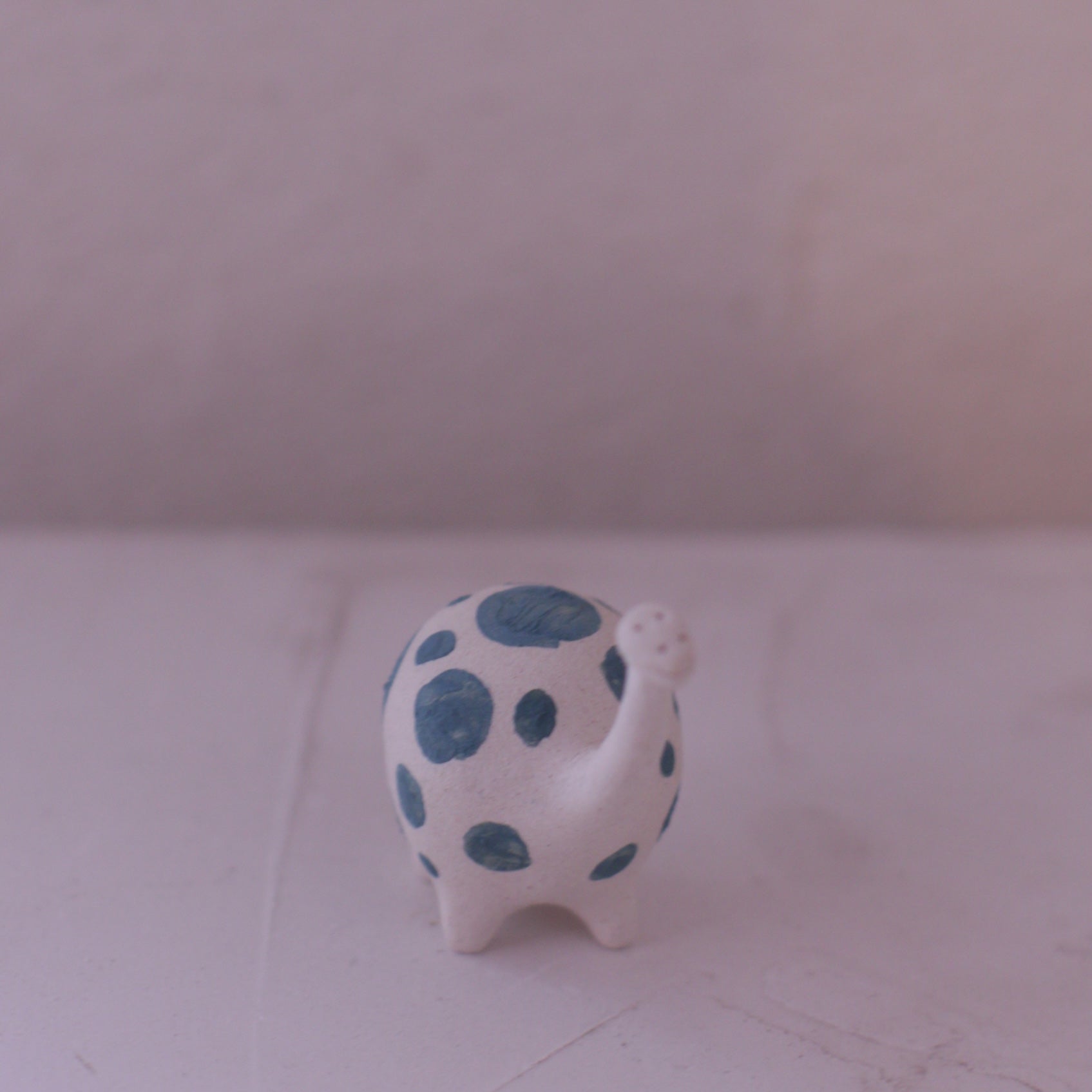 Handmade pottery animal figurine with white body and blue spots crafted by various artist