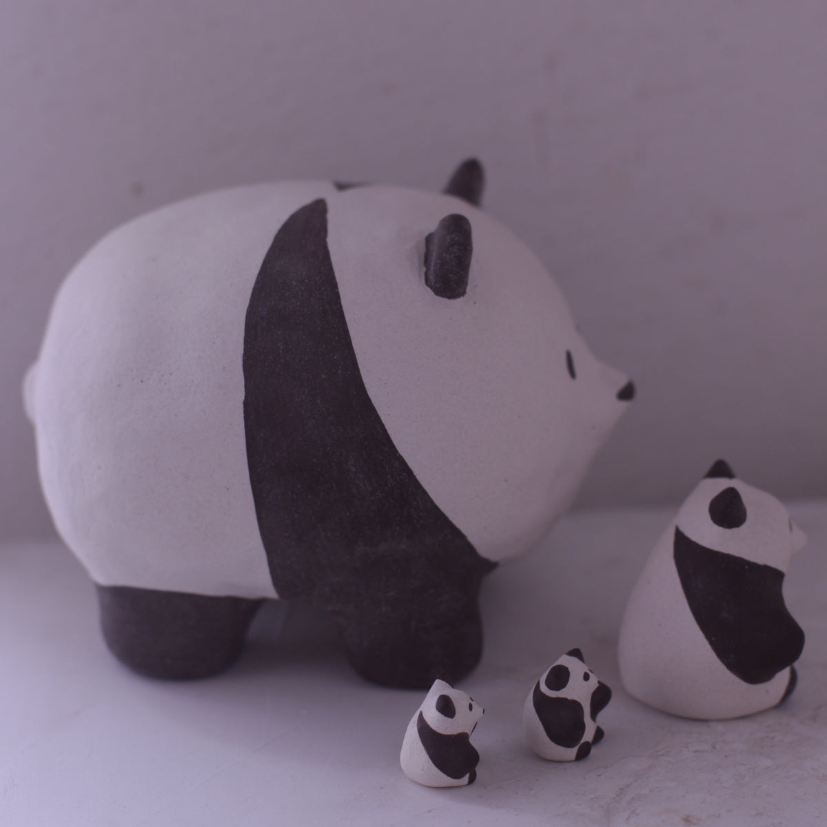Handmade pottery animal figurine set featuring black and white panda designs from various artists