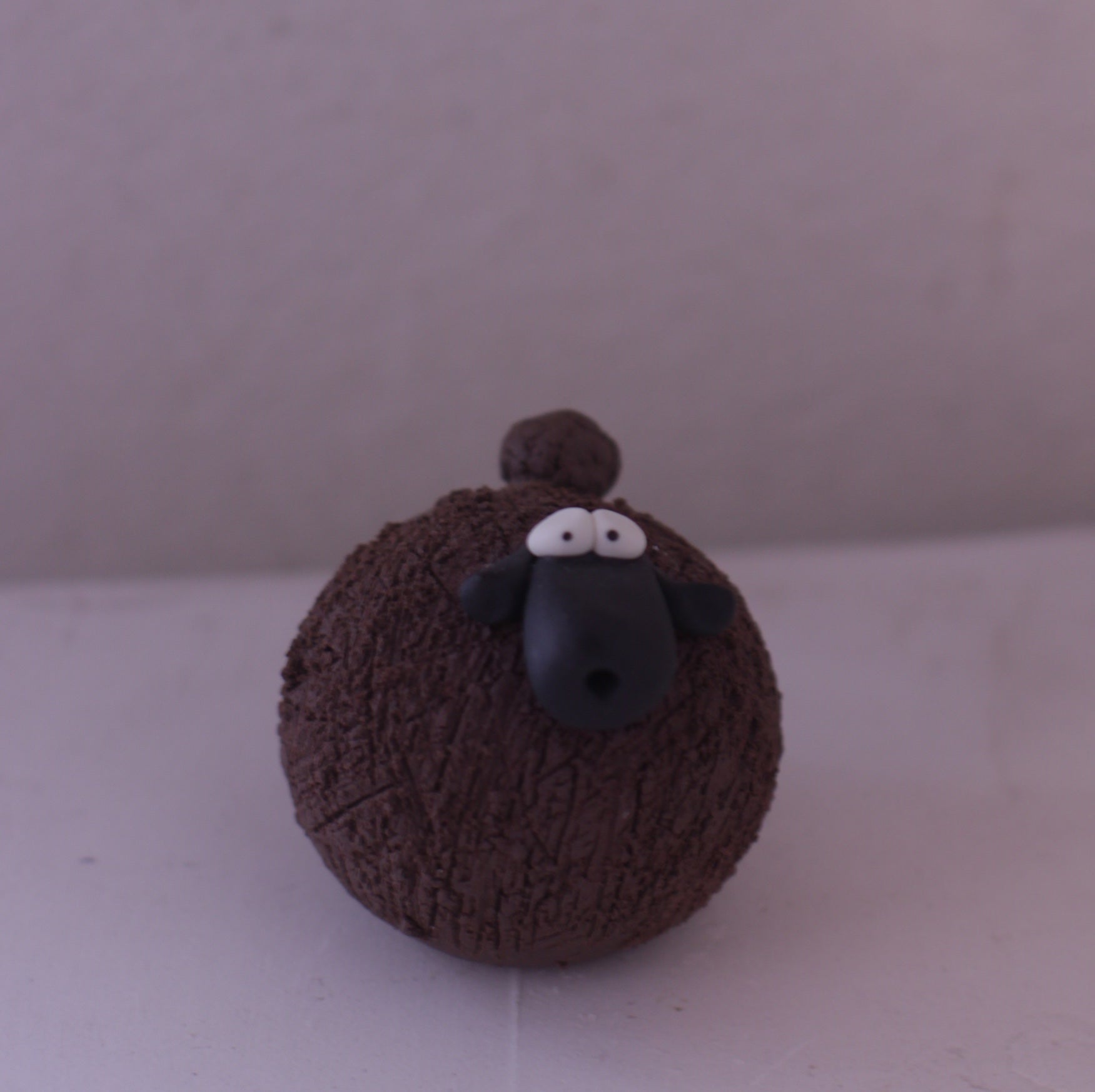 Handmade pottery sheep figurine with textured brown body and black face by Various Artist