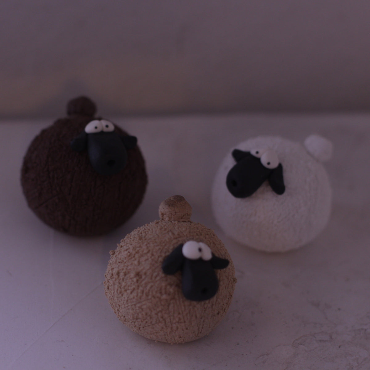 Handmade pottery animal figurine set of three sheep in brown, beige, and white colors