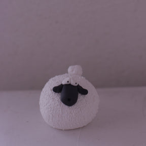 Handmade pottery sheep figurine with textured white body and black face by various artist front view