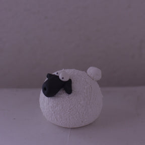 Handmade pottery sheep figurine with textured white body and black face by various artist